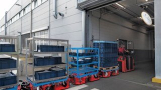 El tren logístico LT10 WX de Linde MH transporta material entre dos naves