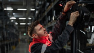 Los sistemas de iluminación y advertencia de Linde Material Handling permiten una manipulación segura y precisa. Técnico de servicio de Linde instalando una solución de iluminación