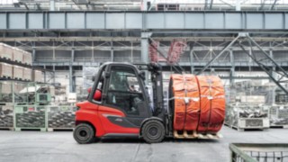 Numerosos sistemas de asistencia aumentan la seguridad para las personas, el vehículo y el entorno. Una carretilla térmica H30 transporta mercancías en un almacén