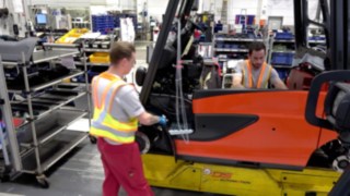 También en el ámbito de la producción es imprescindible guardar las distancias para prevenir contagios, con ayuda del Secure Distance Vest de Linde Dos empleados de la producción mantienen una distancia segura gracias al chaleco de distancia de seguridad de Linde