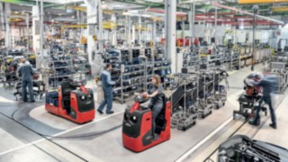 Los tractores con varios soportes de mercancía aumentan la productividad en la alimentación de la producción. Tractores con varios soportes de mercancía transportan componentes a la línea de producción.