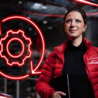 Una empleada de Linde Material Handling en un almacén, con el símbolo de una rueda dentada de color rojo brillante al fondo.