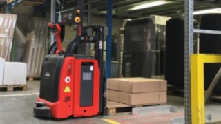 La L-MATIC de Linde Material Handling presta apoyo in situ al equipo de preparación de pedidos. Una L-MATIC de Linde Material Handling deposita en la estantería un palet con paquetes.