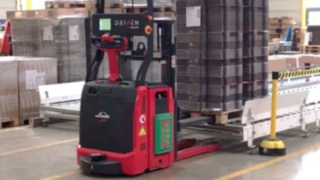 La L-MATIC de Linde Material Handling detecta y posiciona automáticamente la mercancía en el sistema de transporte. Una L-MATIC de Linde Material Handling deposita un palet sobre una cinta transportadora