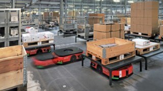 Varios vehículos de plataforma automatizados C-MATIC de Linde MH transportan mercancías en el almacén de ABS Safety. 