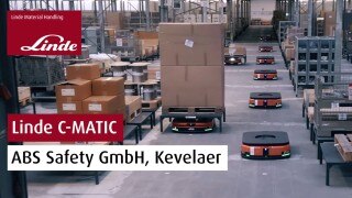 Logotipo de Linde Material Handling y la inscripción "Linde C-MATIC ABS Safety GmbH, Kevelaer" en una fotografía en la que aparecen varios vehículos C-MATIC en el almacén de ABS Safety.