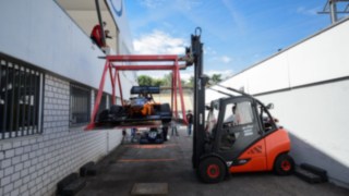 Una carretilla de alquiler de Linde transporta cuidadosamente un monoplaza de competición en un dispositivo especialmente previsto al efecto Una carretilla de alquiler de Linde transporta cuidadosamente un monoplaza de competición