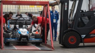 Una carretilla de alquiler de Linde eleva un coche de carreras mediante un dispositivo especial