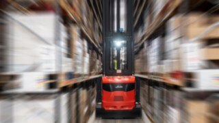Una carretilla de pasillo estrecho (VNA) de Linde Material Handling en acción en un almacén.