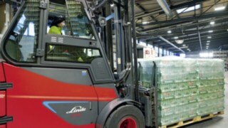 La carretilla eléctrica E80 de Linde Material Handling transporta un palé de cerveza Heineken.