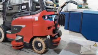 La gestión de la carga de las carretillas elevadoras autónomas es automática. Una carretilla elevadora Linde autónoma durante el proceso de carga.
