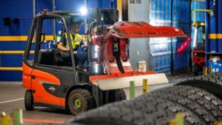Un empleado de Michelin Tyre PLC agarra una pila de neumáticos con una pinza en la Linde E20.