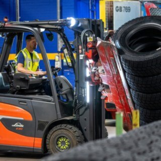 Un empleado de Michelin Tyre PLC sujeta una pila de neumáticos con una pinza montada en la carretilla elevadora.