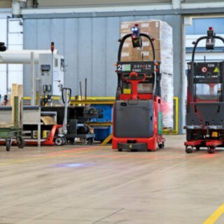 Dos apiladores automáticos L-MATIC transportan mercancías entre la línea de embalaje y el almacén dinámico.