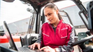 Gracias a los gemelos digitales, nuestros técnicos de servicio pueden realizar diagnósticos y mantenimiento a distancia. Una técnica de mantenimiento comprueba los datos de la carretilla en su ordenador portátil.