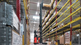 La carretilla elevadora Linde R-MATIC almacena un palé en una estantería de gran altura.