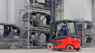 Linde Material Handling ofrece soluciones para los principales retos intralogísticos de la industria automovilística. Una carretilla elevadora de Linde se acerca a una estantería con piezas de carrocería