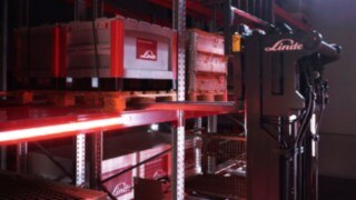 Una carretilla retráctil de Linde del modelo Ri16 transporta palés en una zona de estanterías.