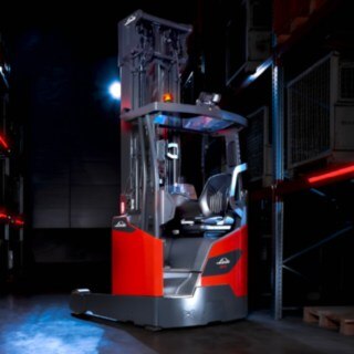 Una carretilla retráctil de Linde MH del modelo Ri16 en un almacén bien iluminado.