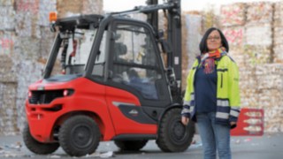 Los conductores están en el centro de la filosofía integral de vehículos de Linde. Una mujer delante de una carretilla elevadora en una fábrica