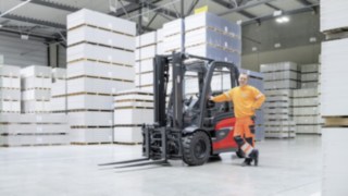 Debido a la escasez de mano de obra cualificada, es especialmente importante posicionarse como empleador atractivo. Un hombre se apoya en una carretilla elevadora en un almacén