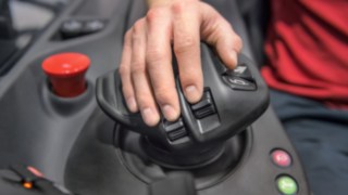 La forma del joystick multifunción de Linde está exactamente adaptada a la anatomía humana. Mano del operario apoyada sobre el joystick multifunción de Linde Material Handling