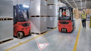 Linde TruckSpot indica la aproximación de la carretilla mediante una señal luminosa. Linde TruckSpot en acción.